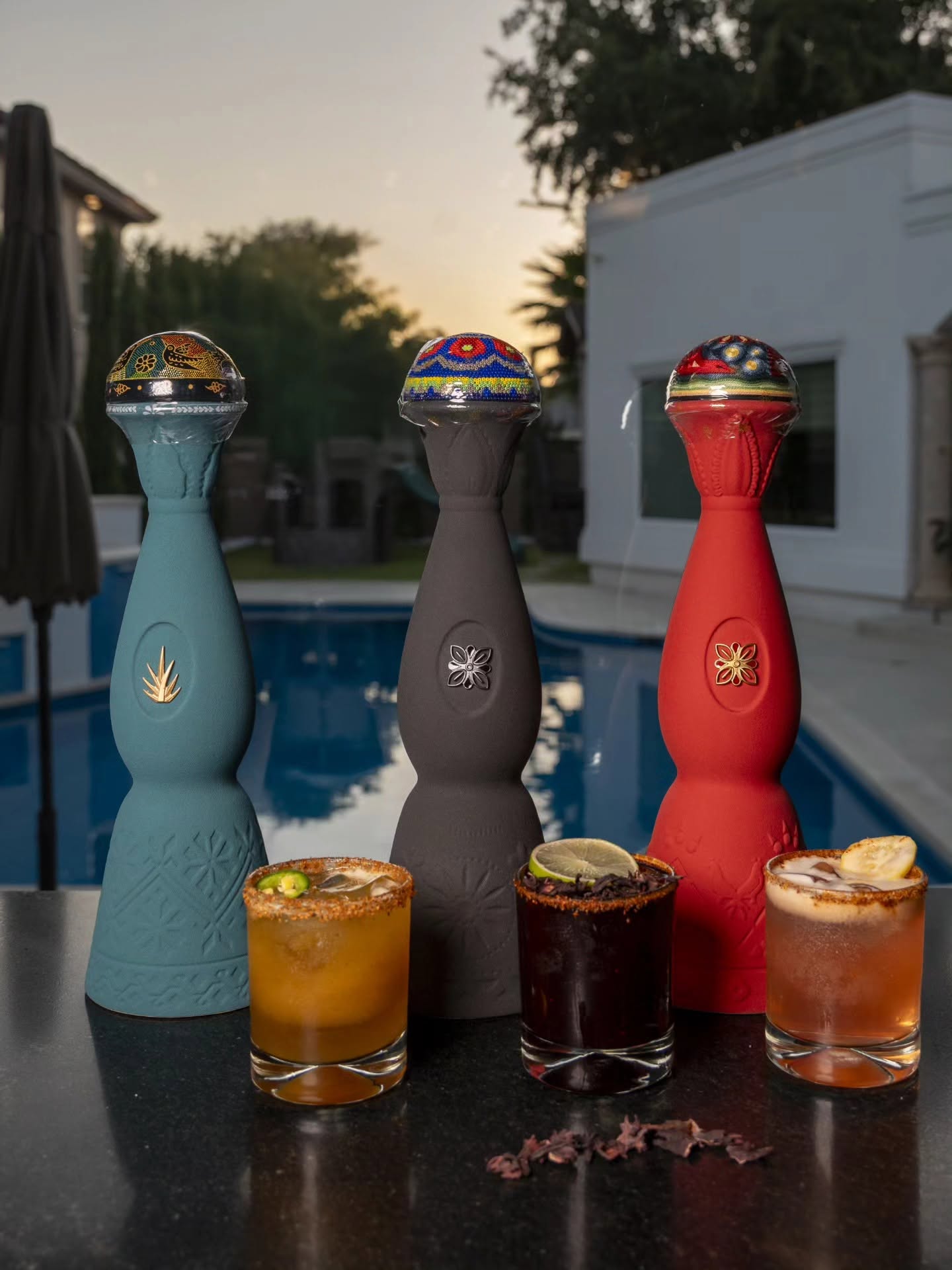 Premium tequila bottles and margaritas at the La Mezcla poolside bar at sunset